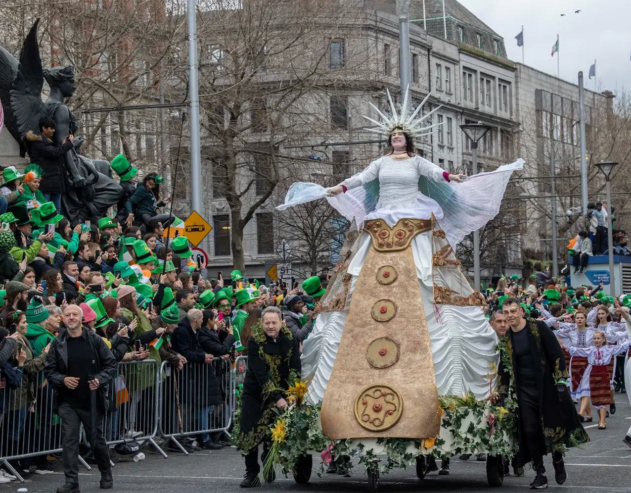 Woman on float wearing big dress as crowd watches on for parade