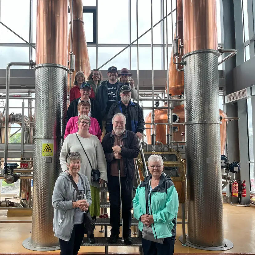 Group Tour standing in front of lots of pipes used for brewing