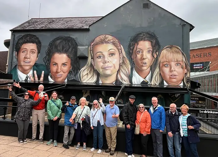 Tour in front of Derry Girls TV Show mural