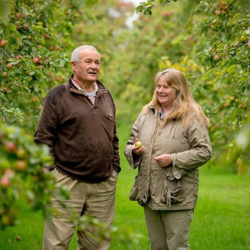 Orchard Owners posing in front of apple trees