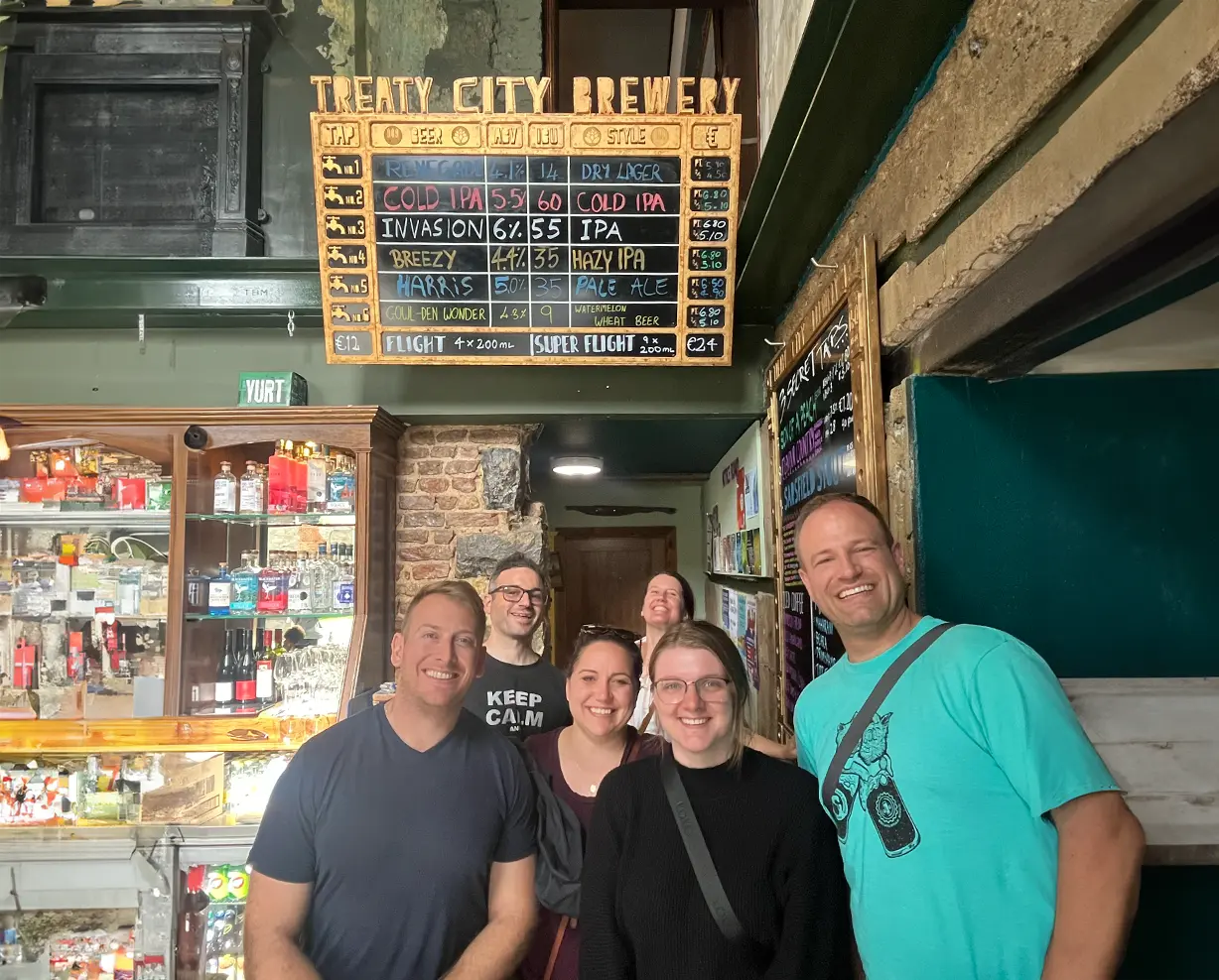 Tour members in front of Treaty City Brewery Menu